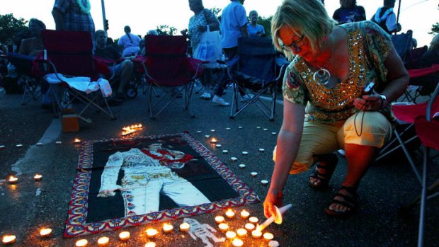 Elvis Presley fan Jill Gibson lights candles outside Graceland, Presley's home, before the annual candlelight vigil in Memphis, Tennessee.