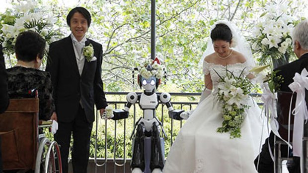 I-Fairy the robot with the bride and groom, Tomohiro Shibata  and Satoko Inoue in Tokyo.