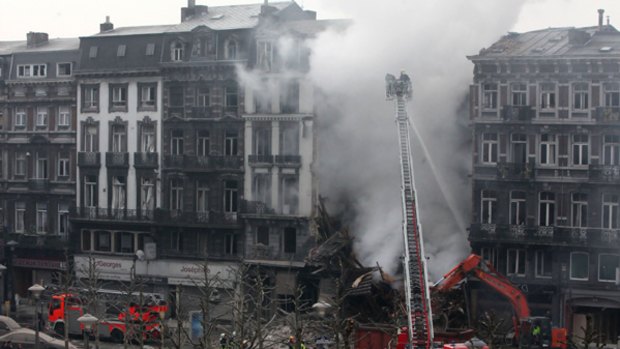 Firemen try to extinguish a fire at the collapsed building.