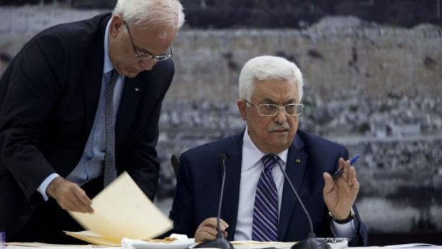 Palestinian President Mahmoud Abbas, right, with chief negotiator Saeb Erekat, signs an application to UN agencies. 