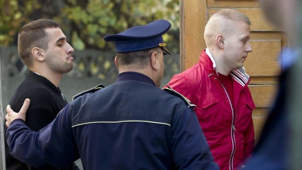 Eugen Darie, right, and Alexandru Bitu, left, two suspects charged with stealing paintings worth millions from a Dutch museum, enter a court building for a hearing in Bucharest, Romania.