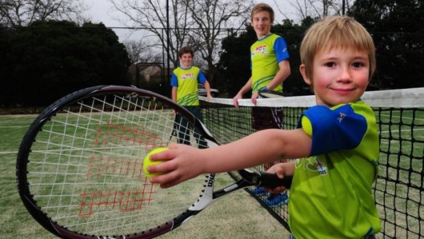 Junior tennis players Owen Bamford, 5, front, with his brothers Griffin, 11, left, and Lachlan, 13, all of Barton at the Reid Tennis Club, Canberra.