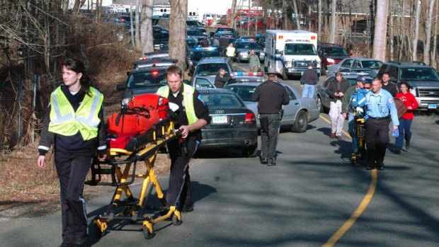 Paramedics push stretchers towards Sandy Hook Elementary.