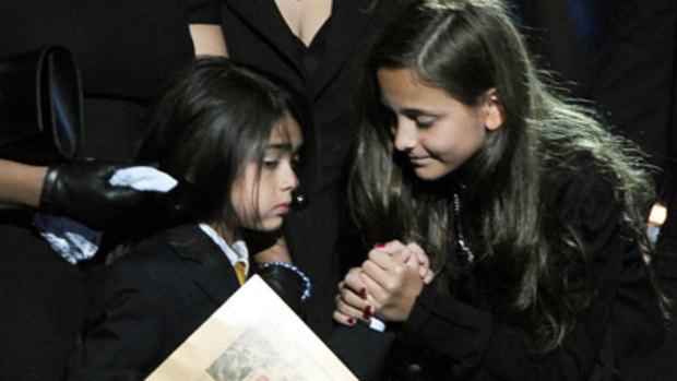 Michael Jackson's daughter Paris Katherine (R) holds the hand of her younger brother Prince Michael Jackson II.