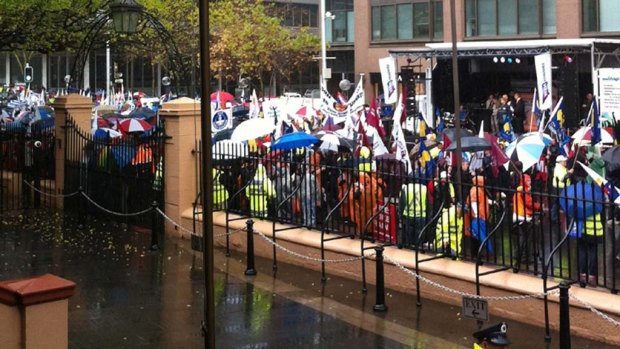 Storming the gates ... thousands of workers rally outside NSW Parliament to protest against expected cuts to the state's WorkCover scheme.