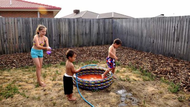 Studies have shown that the suburb of Macgregor was up to 7 degrees hotter than certain southside suburbs. L-R Aideen Fitzgerlad,9,  cools off with Nate Fitzgerald,2,  and Seth Fitzgerald,5  in their backyard in Macgregor.