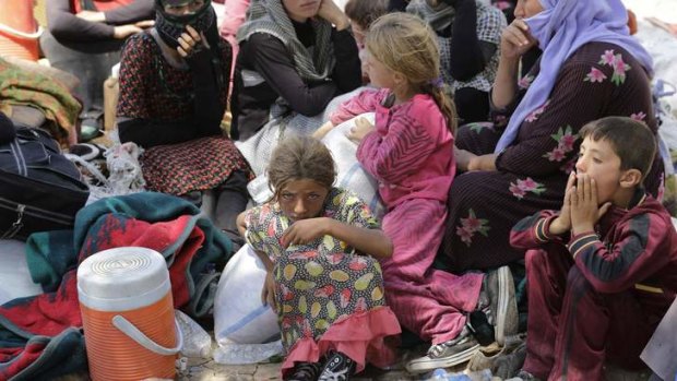 Displaced people from the minority Yazidi sect, fleeing the violence in the Iraqi town of Sinjar, rest at the Iraqi-Syrian border crossing.