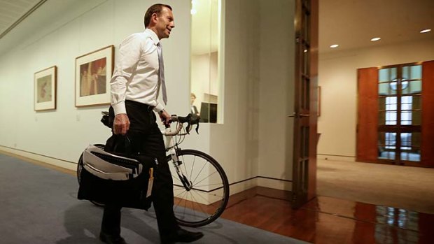 Prime Minister-elect Tony Abbott wheels his bicycle from his old office to his Prime Ministerial office, at Parliament House in Canberra on Monday.