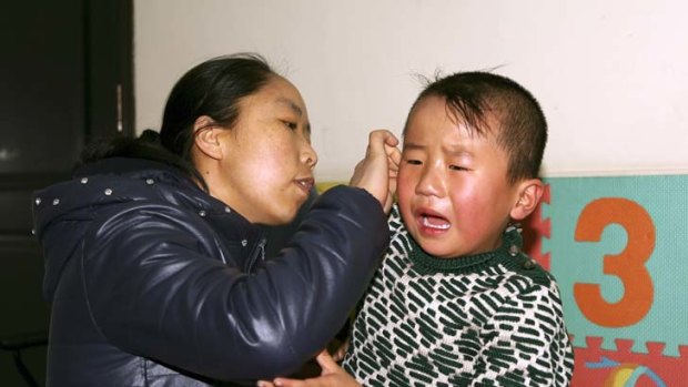 Breaking the silence &#8230; Shang Xiaowei comforts her son Tong Zhenhua, 4, as he reacts to hearing for the first time after his cochlear implant is switched on.
