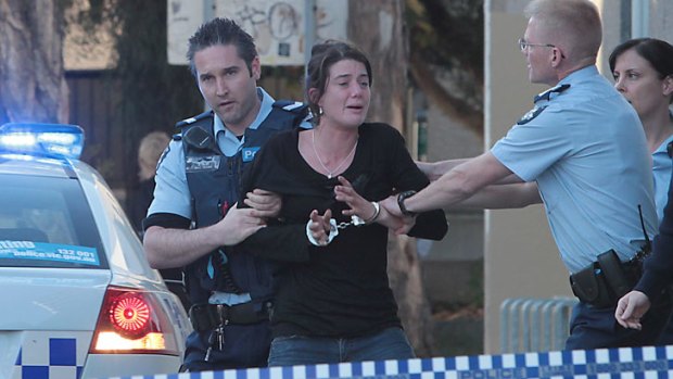 Police arrest a woman outside the CentreLink offices in Prahran.