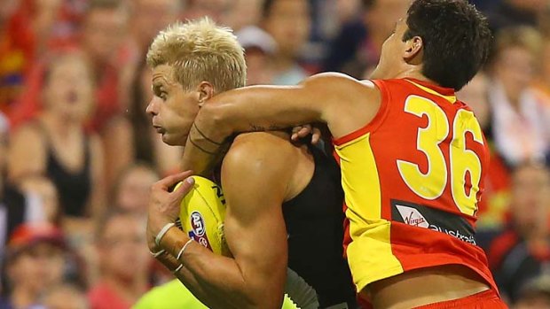 Nick Riewoldt takes a grab under heavy pressure from Gold Coast's Greg Broughton.
