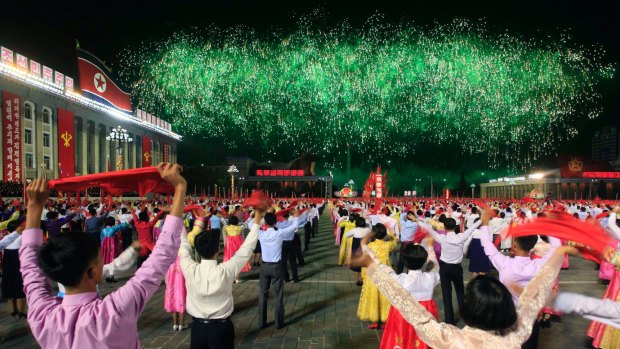 North Koreans cheer as fireworks explode over the Taedong river.