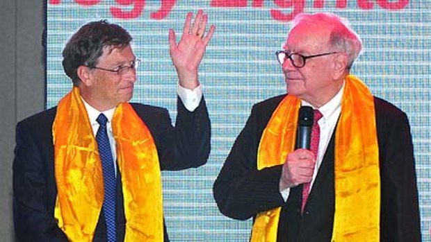 Wearing gift  scarves, Warren Buffett  and Bill Gates at the nationwide launch ceremony of Chinese electric vehicle BYD M6 in Beijing yesterday.