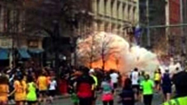 In this image from video provided by WBZ TV, spectators and runners run from what was described as twin explosions that shook the finish line of the Boston Marathon.