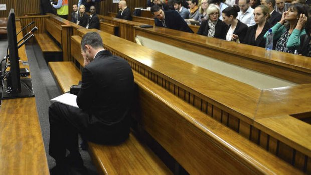 Bowing his head: Oscar Pistorius in the dock on the second day of his trial in Pretoria on Tuesday.