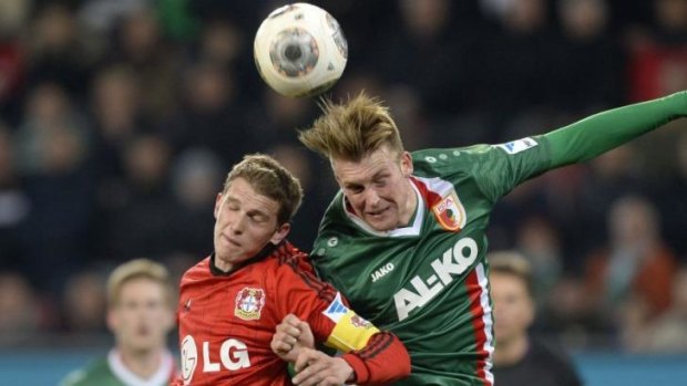 Lars Bender (L) and Augsburg's defender Jan-Ingwer Callsen-Bracker fight for possession.