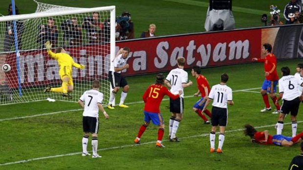Hero ... Spain's Carles Puyol, on the ground, heads the winning goal.