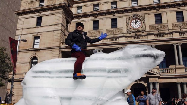 Sculptor Mark Coreth rides his life size ice polar bear in Circular Quay in central Sydney.