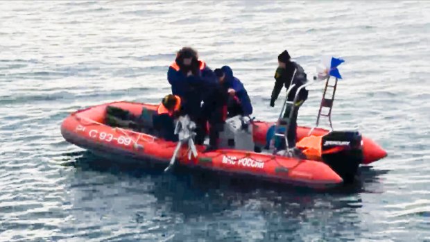 Rescue workers lift a fragment of the plane from waters outside Sochi.