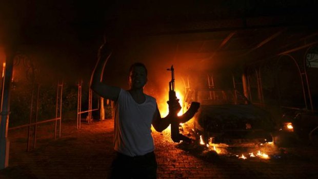 An armed man outside the burning US Consulate in Benghazi.