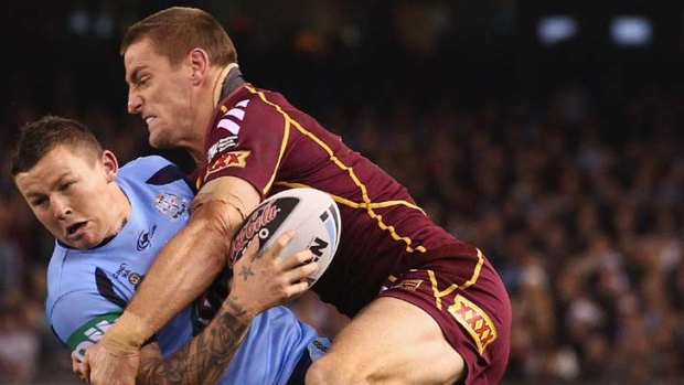 Passion play &#8230; Blues five-eighth Todd Carney is tackled by Maroons winger Brent Tate last night.