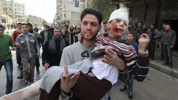 A man carries a wounded child through the streets of Aleppo last month.