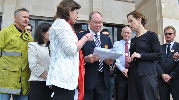 ACTU president Ged Kearney (left) and Unions WA secretary Simone McGurk (right) hand the petition to Opposition leader Eric Ripper.