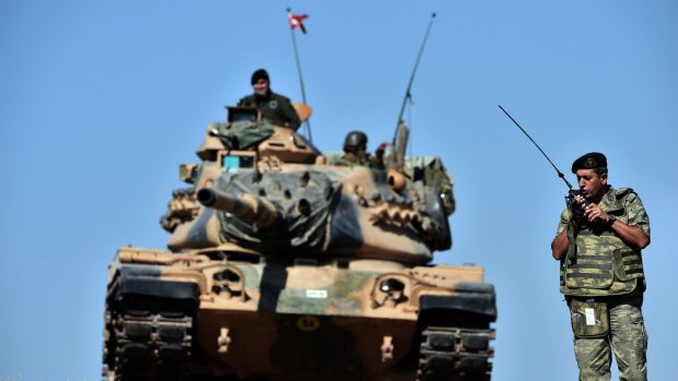 An officer directs operations as Turkish tanks deploy on the Syrian border.