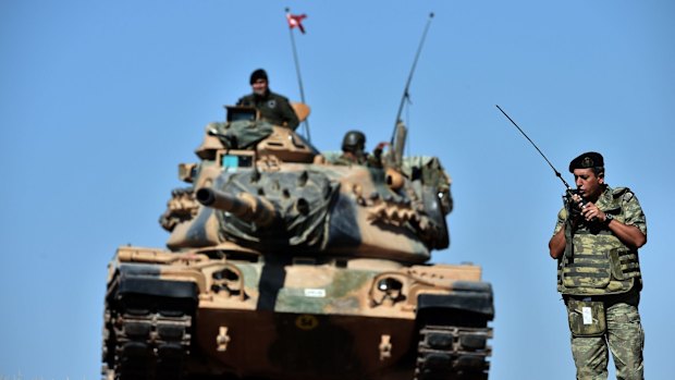 An officer directs operations as Turkish tanks deploy on the Syrian border.