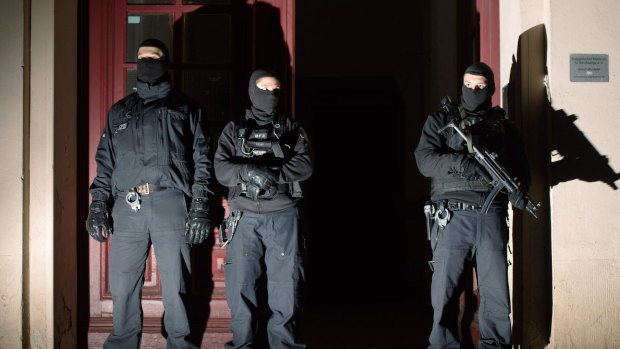 Special police force guards the entrance of a house in Berlin as police raids several residences in Berlin on suspicion of recruiting fighters and procuring equipment and funding for the so-called Islamic State terrorism group in Syria.