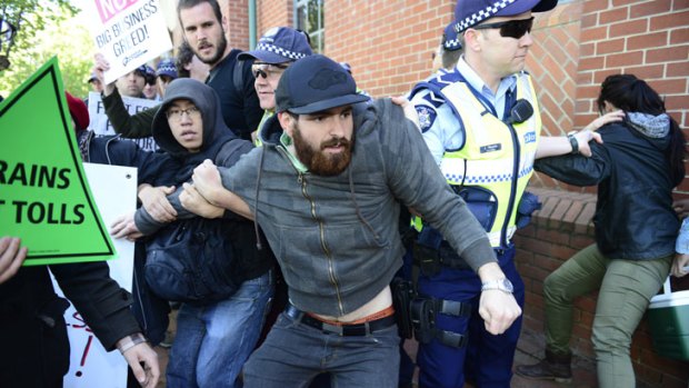 Clash ... Police grab east-west link protesters outside the Collingwood offices.