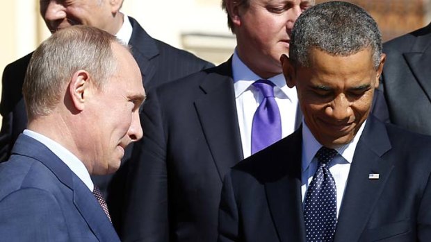At odds: Russian President Vladimir Putin walks past US President Barack Obama during a group photo at the G20 Summit in St Petersburg.