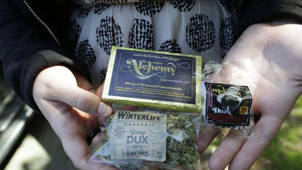 A customer who identified herself as "Tracy" displays dried marijuana, a pot-infused chocolate bar and a marijuana truffle that she bought in Seattle. 