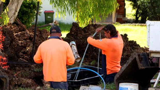 Workers install cables for the national broadband network.