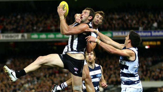 Travis Cloke of the Magpies marks under pressure from Corey Enright.