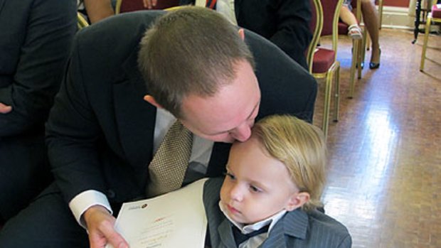 New minister Curtis Pitt kisses son Tristan ahead of his swearing-in.
