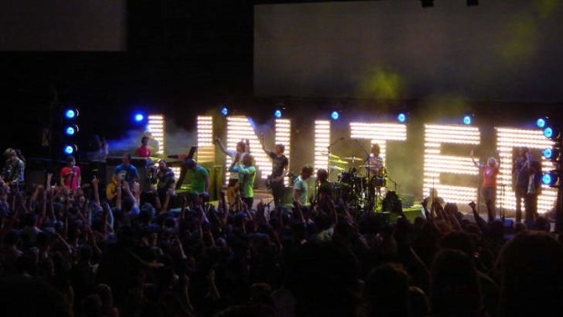 Hillsong United playing onstage to followers.