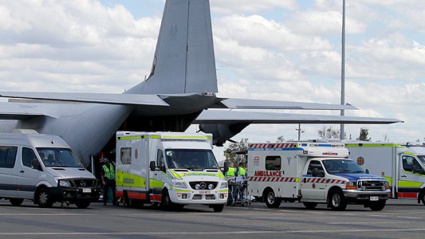 Patients evacuated from Bundaberg are loaded onto ambulances at Brisbane Airport.