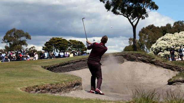England's Ian Poulter hits out of the bunker on the 6th hole.