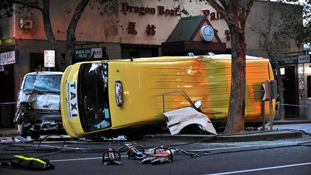 The maxi-cab lies on its side near the intersection of Lonsdale and Russell street.