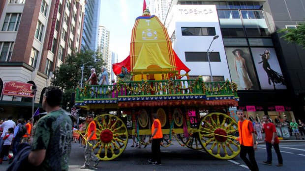 A large hand-drawn chariot is pulled through the streets of Brisbane as part of the Festival of Chariots.