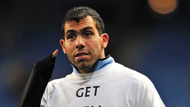 Heart on the sleeve: Manchester City's Carlos Tevez supports the recovering Fabrice Muamba.