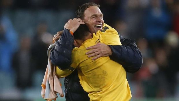 Happy ending: Tim Cahill embraces coach Holger Osieck after the match.