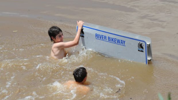 Luke Gaffey and Eddie Jackson, who are both 13, swim in a car park in Wagga Wagga.