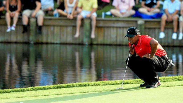 Victory in sight: Tiger Woods lines up a putt on the 18th green.