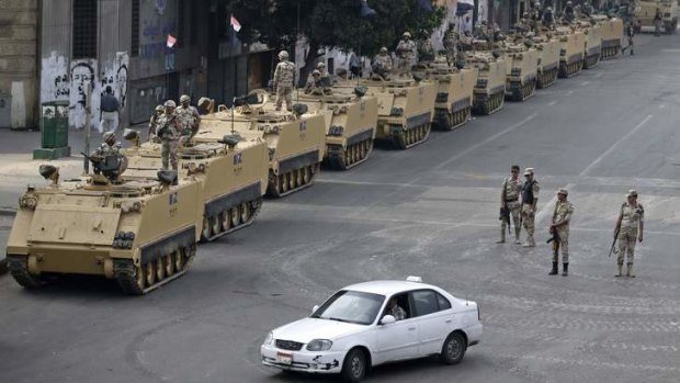 Egyptian army soldiers take their positions on top and next to their armoured vehicles to guard an entrance of Tahrir square, in Cairo, Egypt.