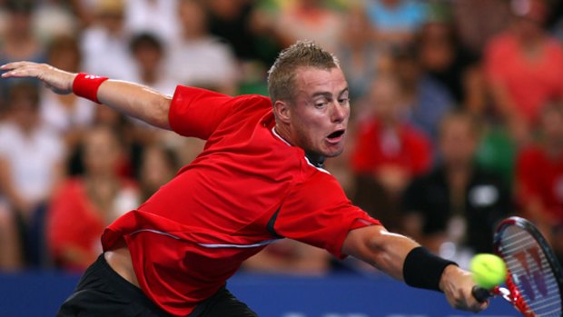 Arms wide open ... Lleyton Hewitt stretches to get back a return against American John Isner in the Hopman Cup tie in Perth.
