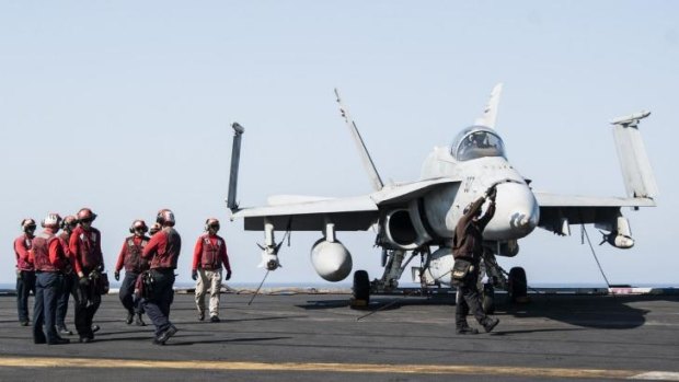 Ground crew on a US aircraft carrier prepare a fighter jet for take-off. Turkey has approved take-offs from bases close to the Syrian border.