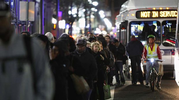Residents line up for a bus in Manhattan.