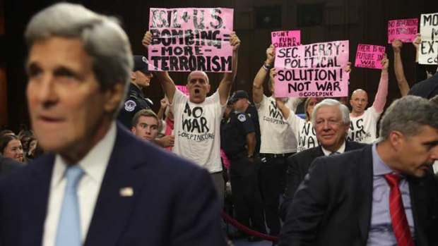 US Secretary of State John Kerry faces protesters as he takes his seat at a hearing before the Senate Foreign Relations Committee last week.